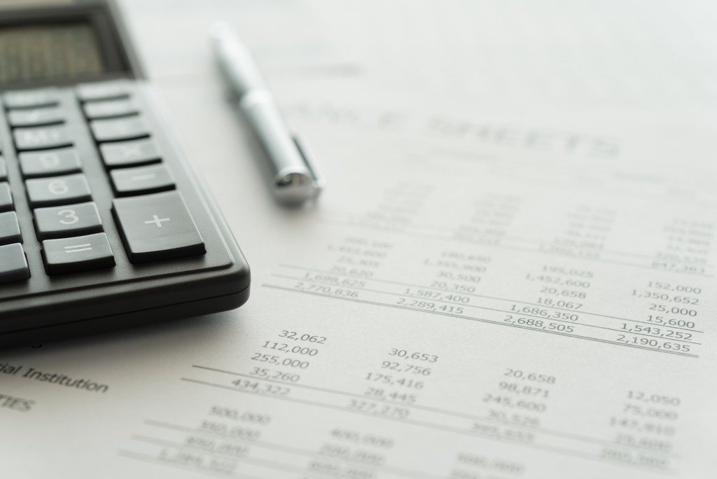 Calculator and pen on a balance sheet