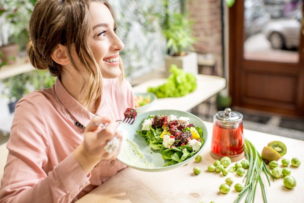 woman happy and eating salad she made