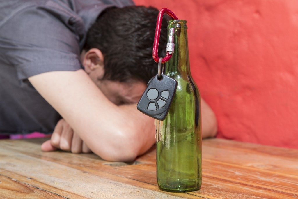 man passed out with keys on a bottle