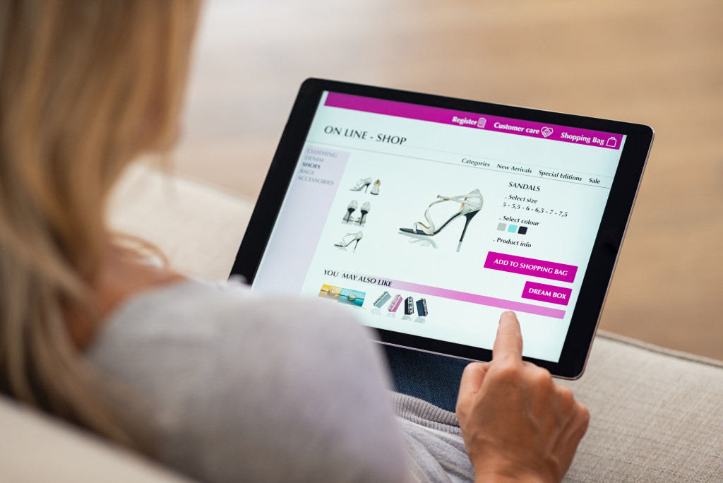 a woman on a digital tablet looking at a shoe store