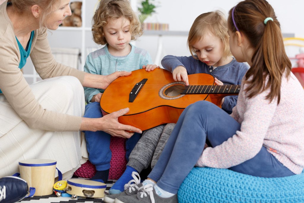 Kids learning how to play the guitar